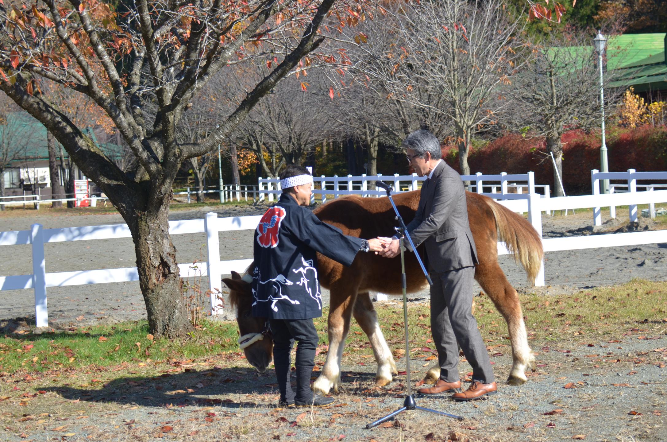 鈴晴を譲渡され市長と握手する鈴木さん