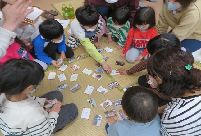 子どもたちがカルタで遊んでいる様子