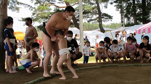 工藤良平さんと子供が相撲を取っている様子