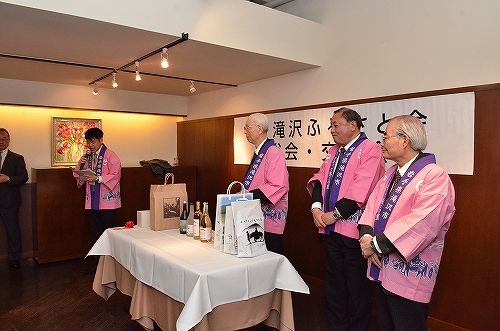 半纏を着た男性たちの前に瓶が並べられている様子