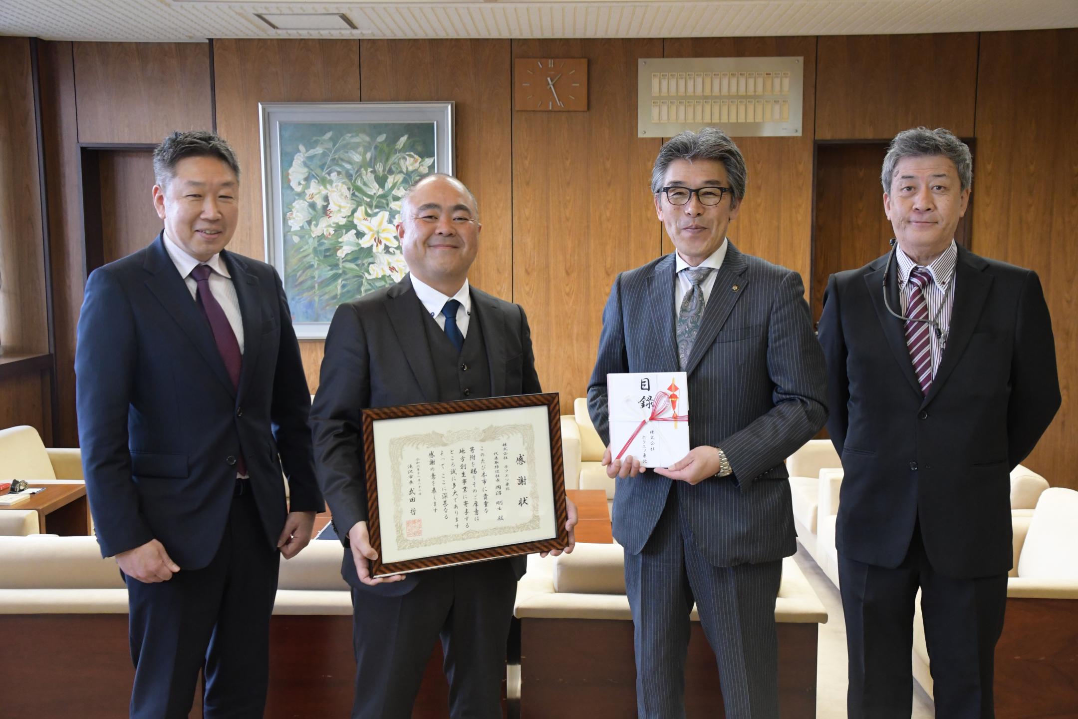 目録、感謝状を手に記念撮影をする様子