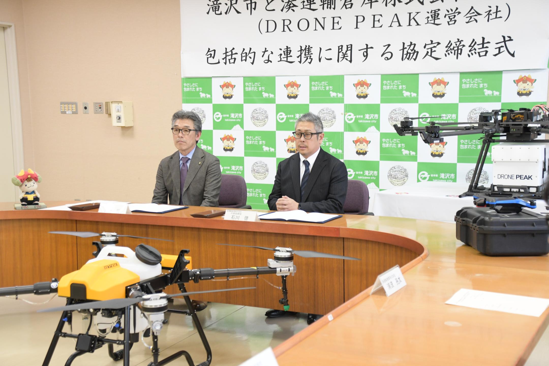 記者から取材をうける石川代表取締役と市長