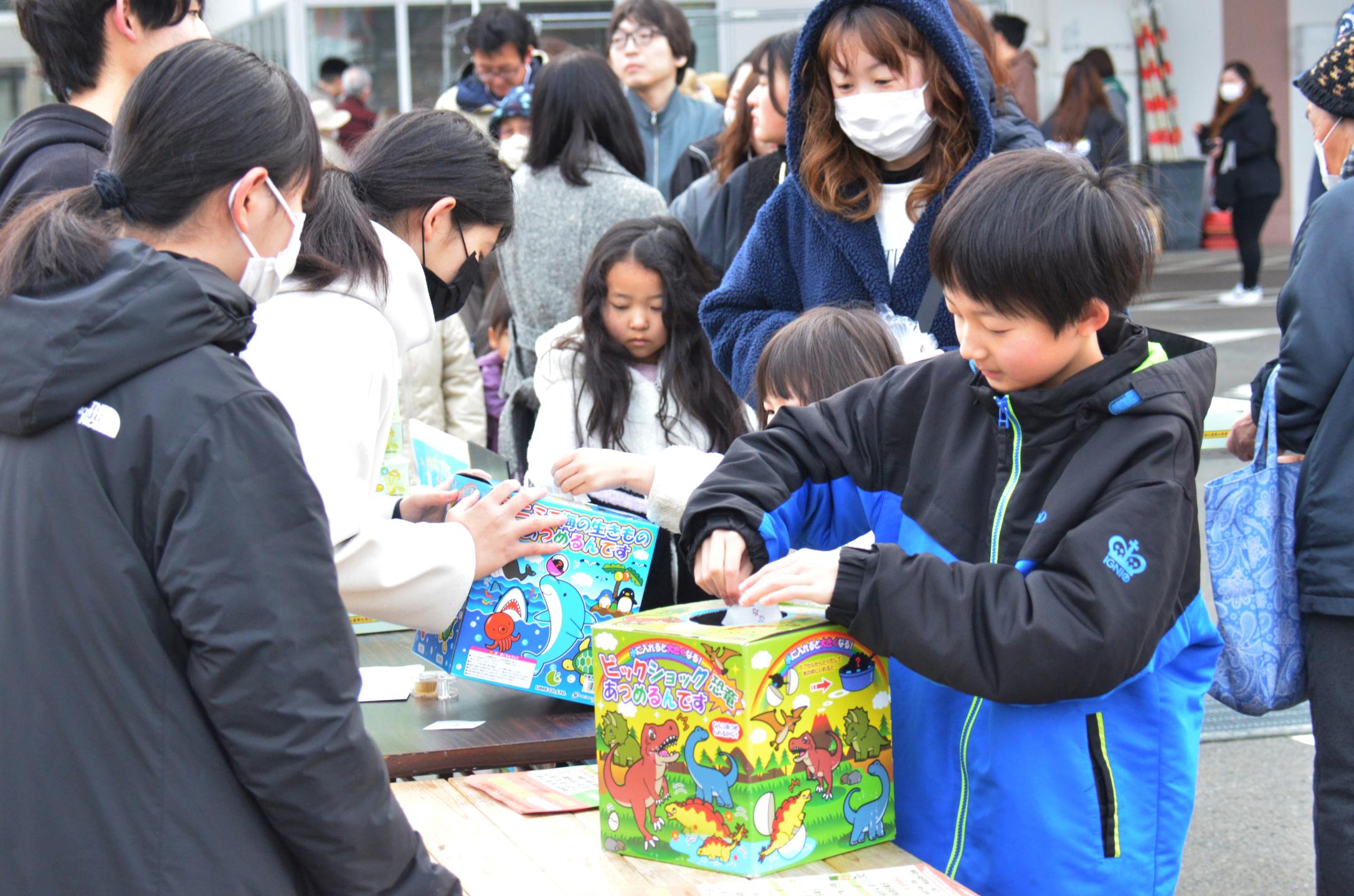 抽選会でくじを引く少年