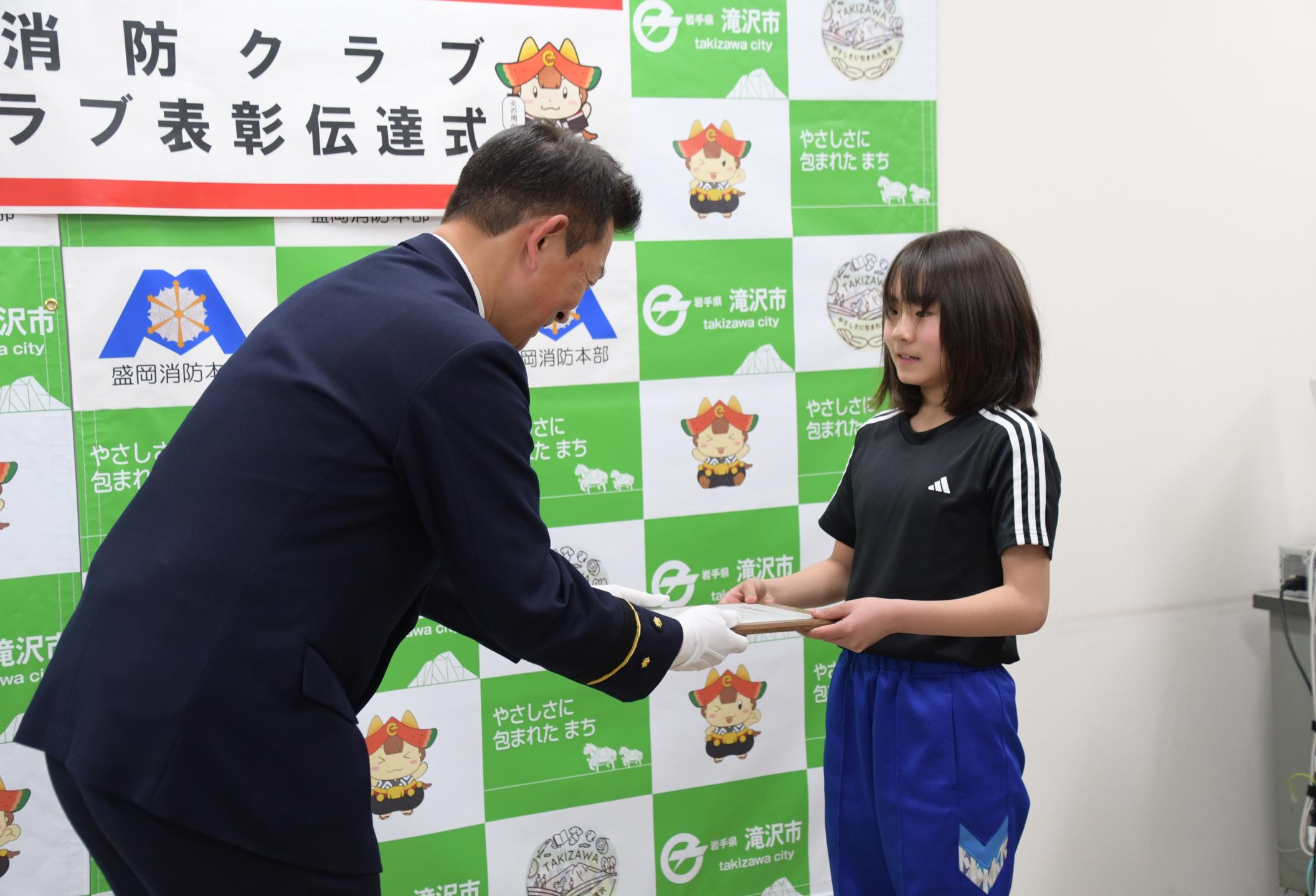 滝沢消防署長から表彰状を受け取る大川さん