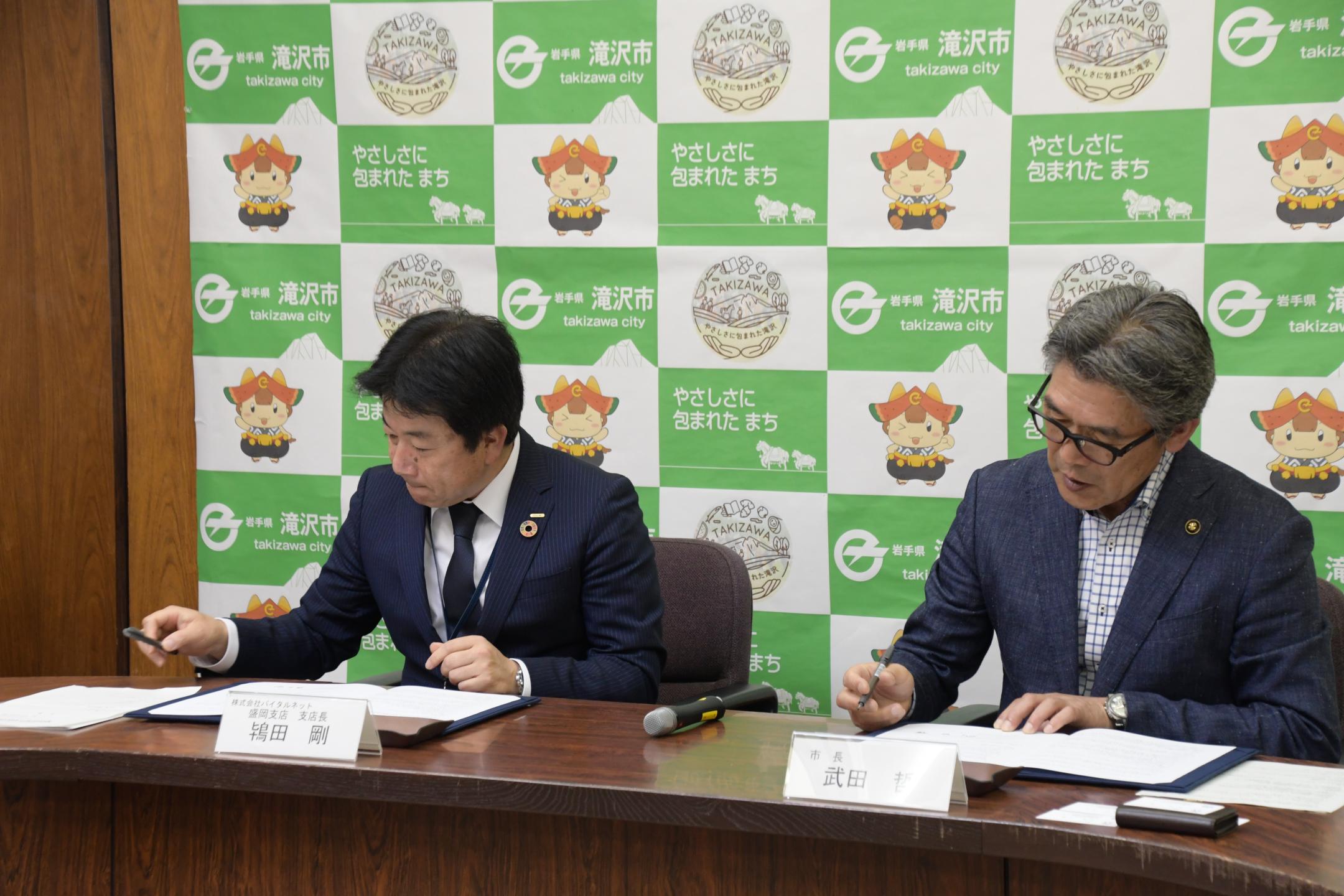 連携協定書に署名する市長と鴇田盛岡支店長