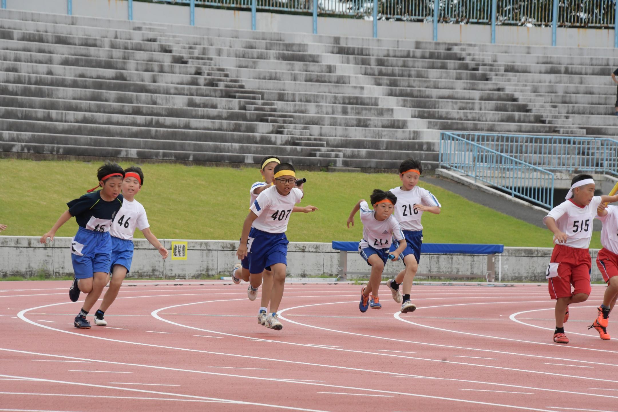 リレーでバトンパスをする選手