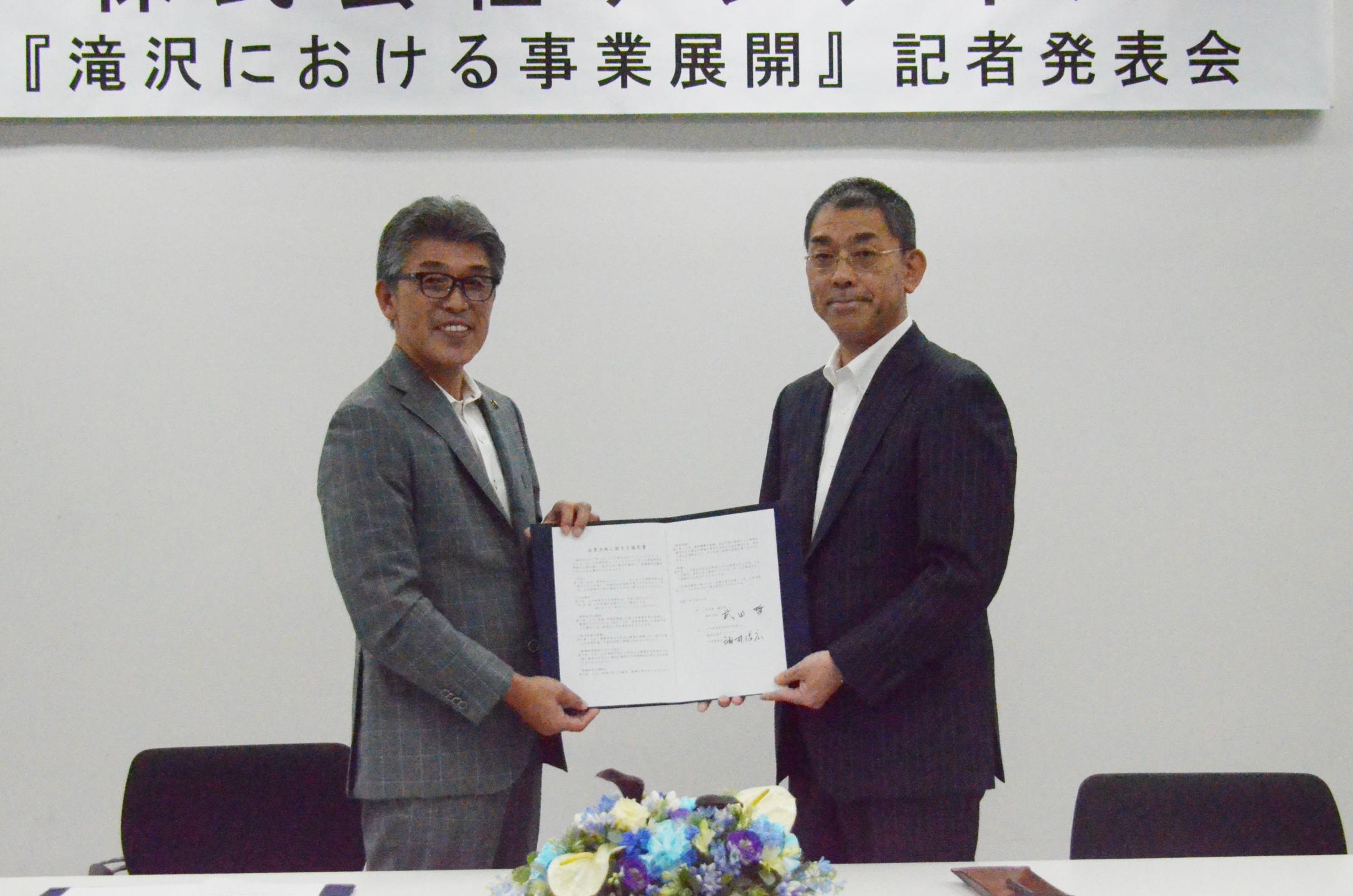 協定書を手に記念撮影