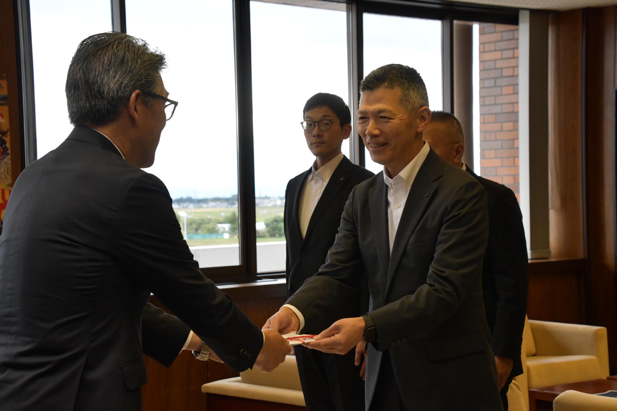 目録を受け取る市長