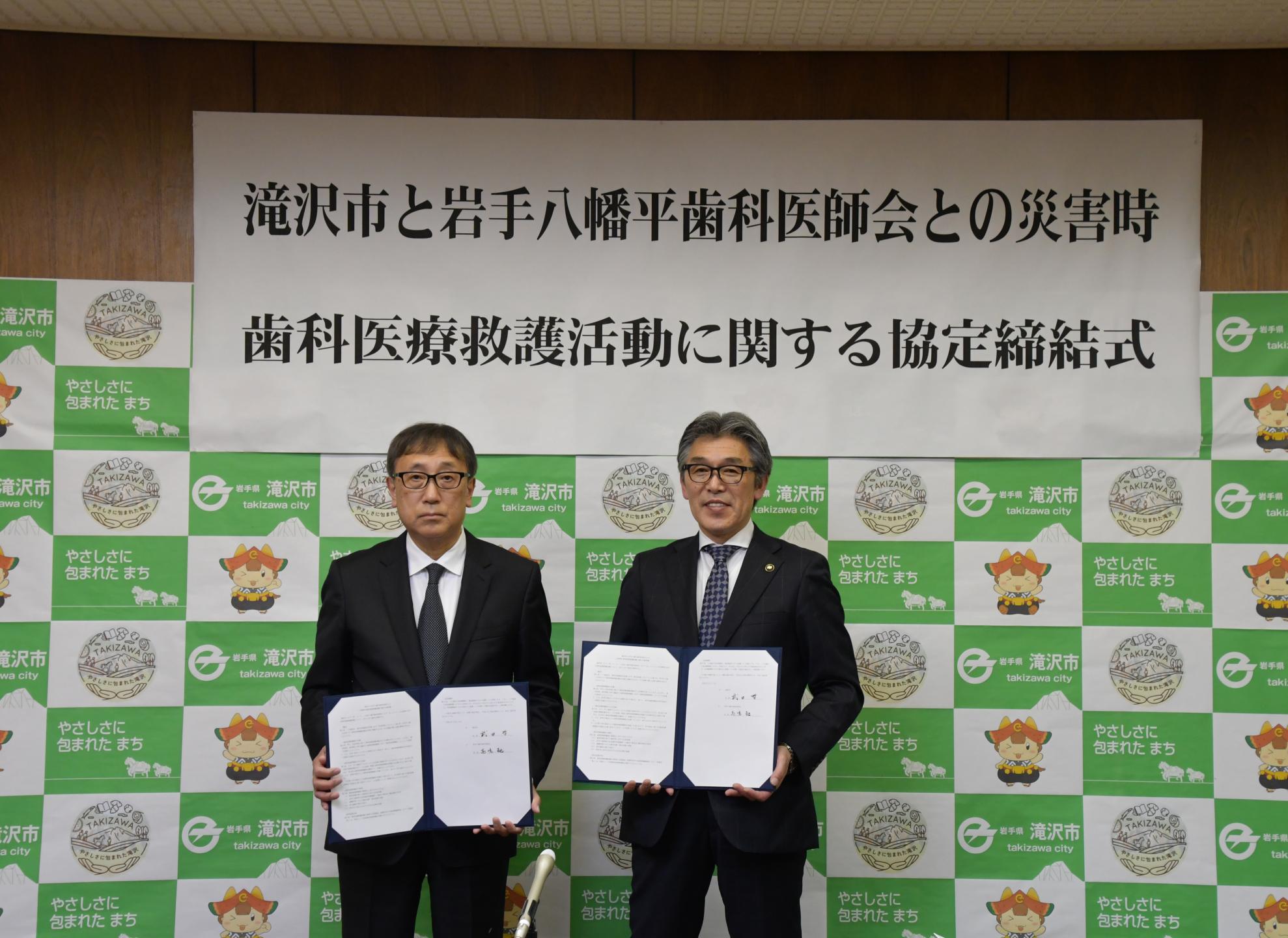 協定書を手に記念撮影