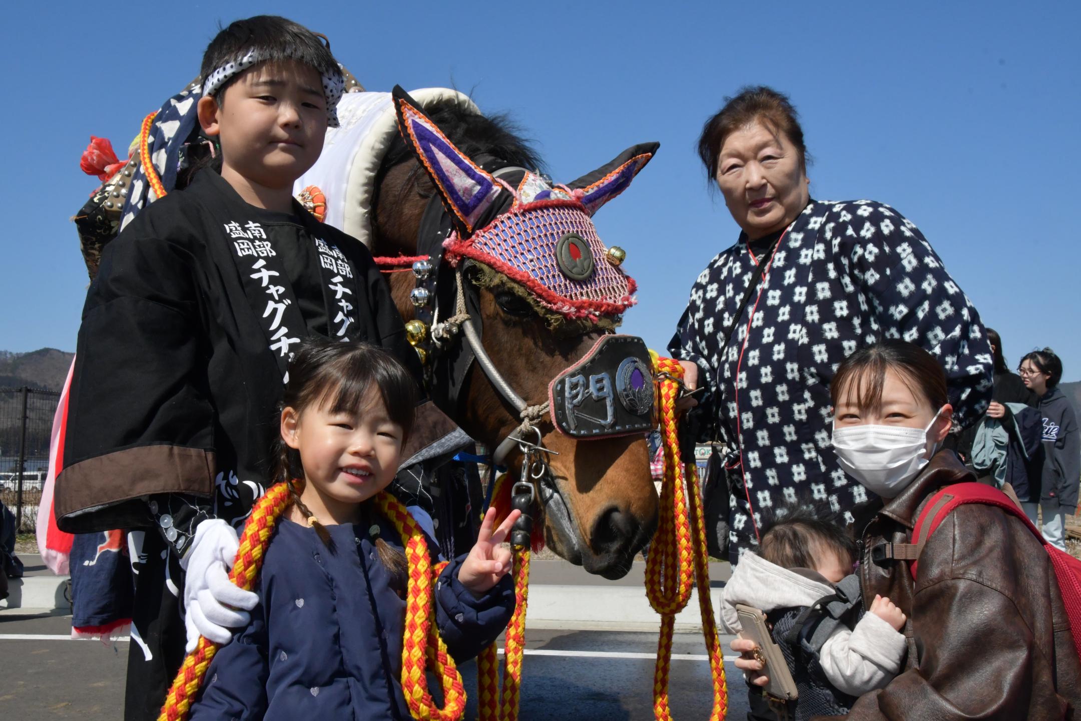 チャグチャグ馬コを記念撮影する親子