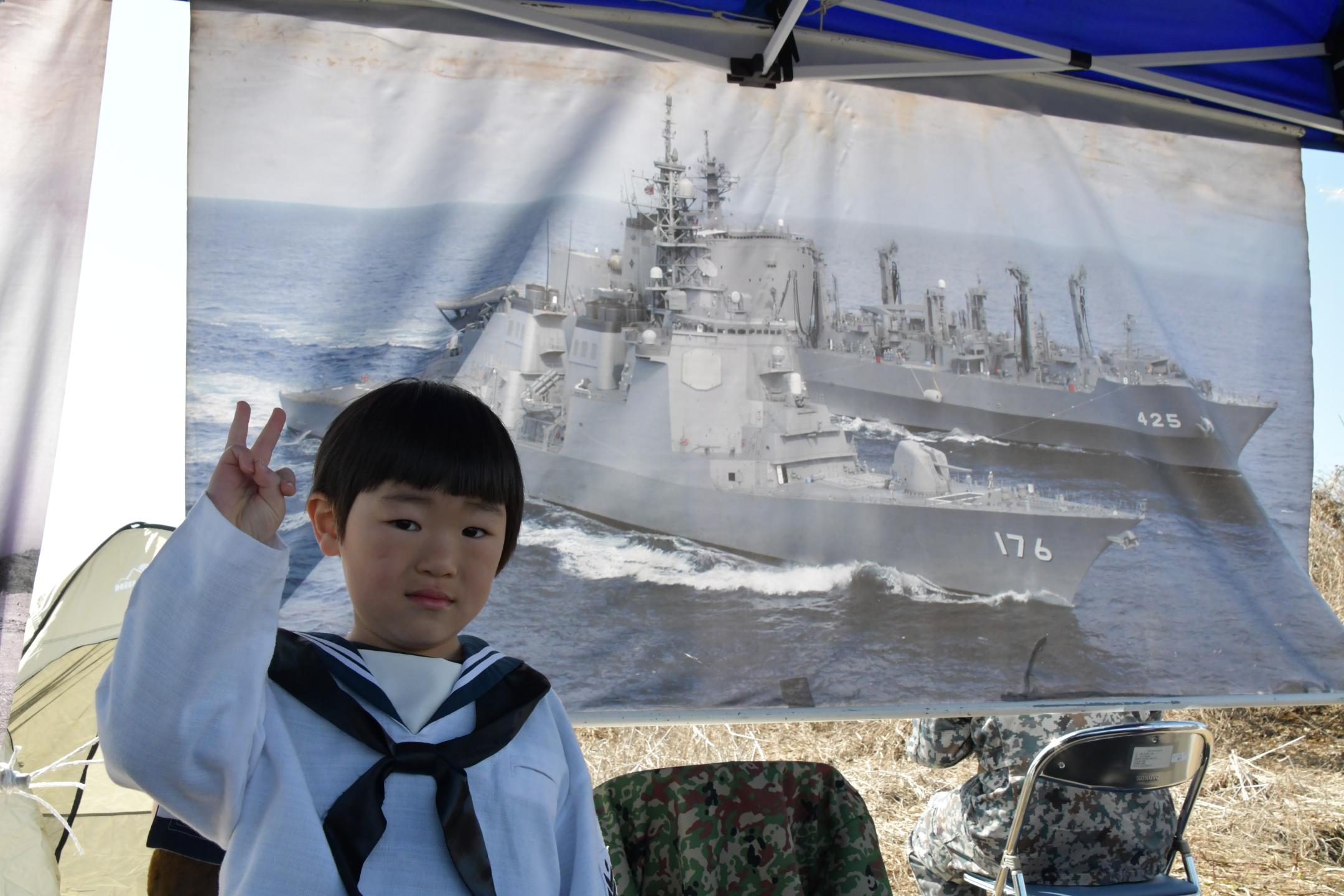 海上自衛隊の制服を着て記念撮影する子供