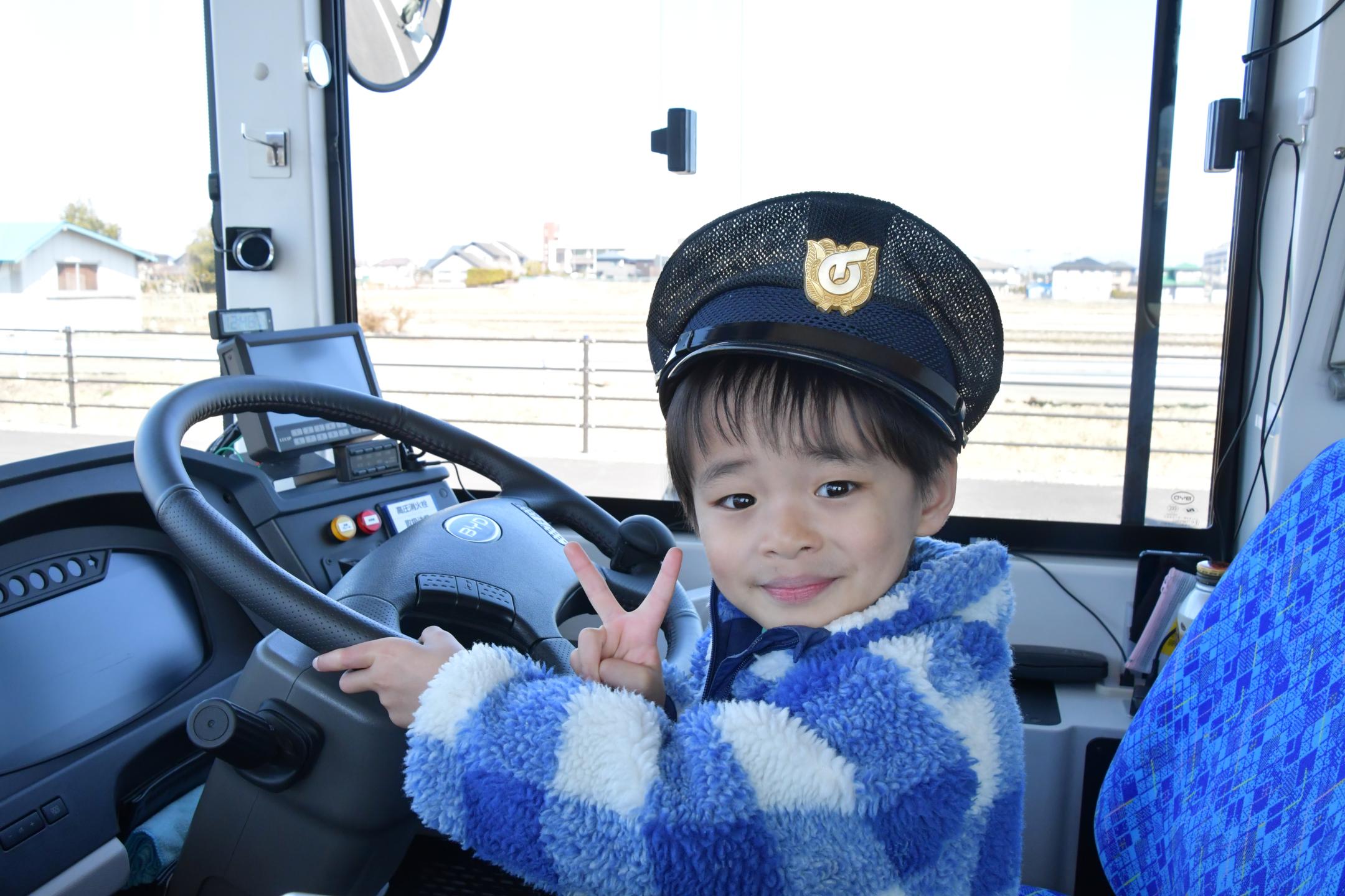 バスの運転席で記念撮影する子供