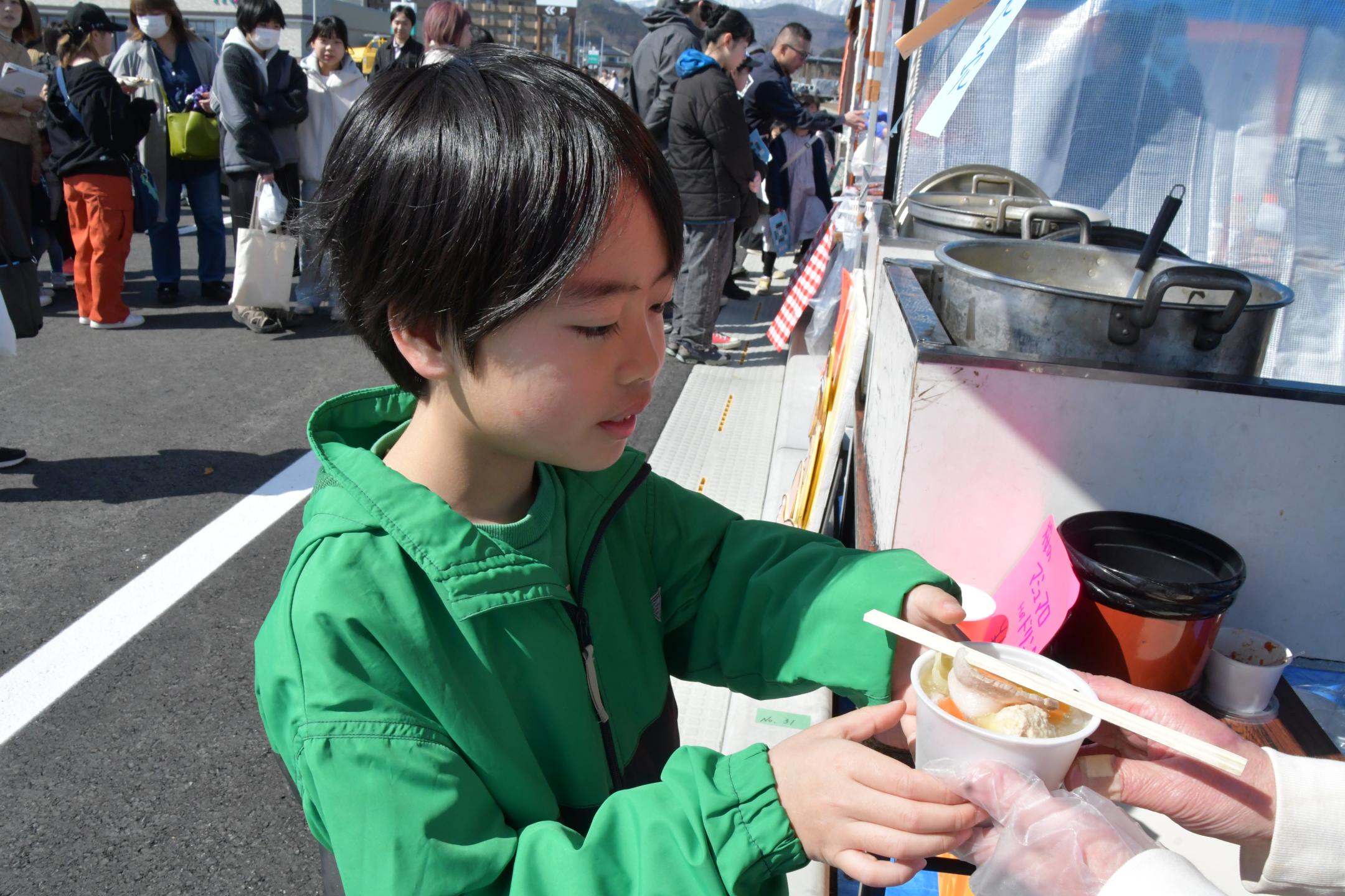 飲食店舗の商品を受け取る子供