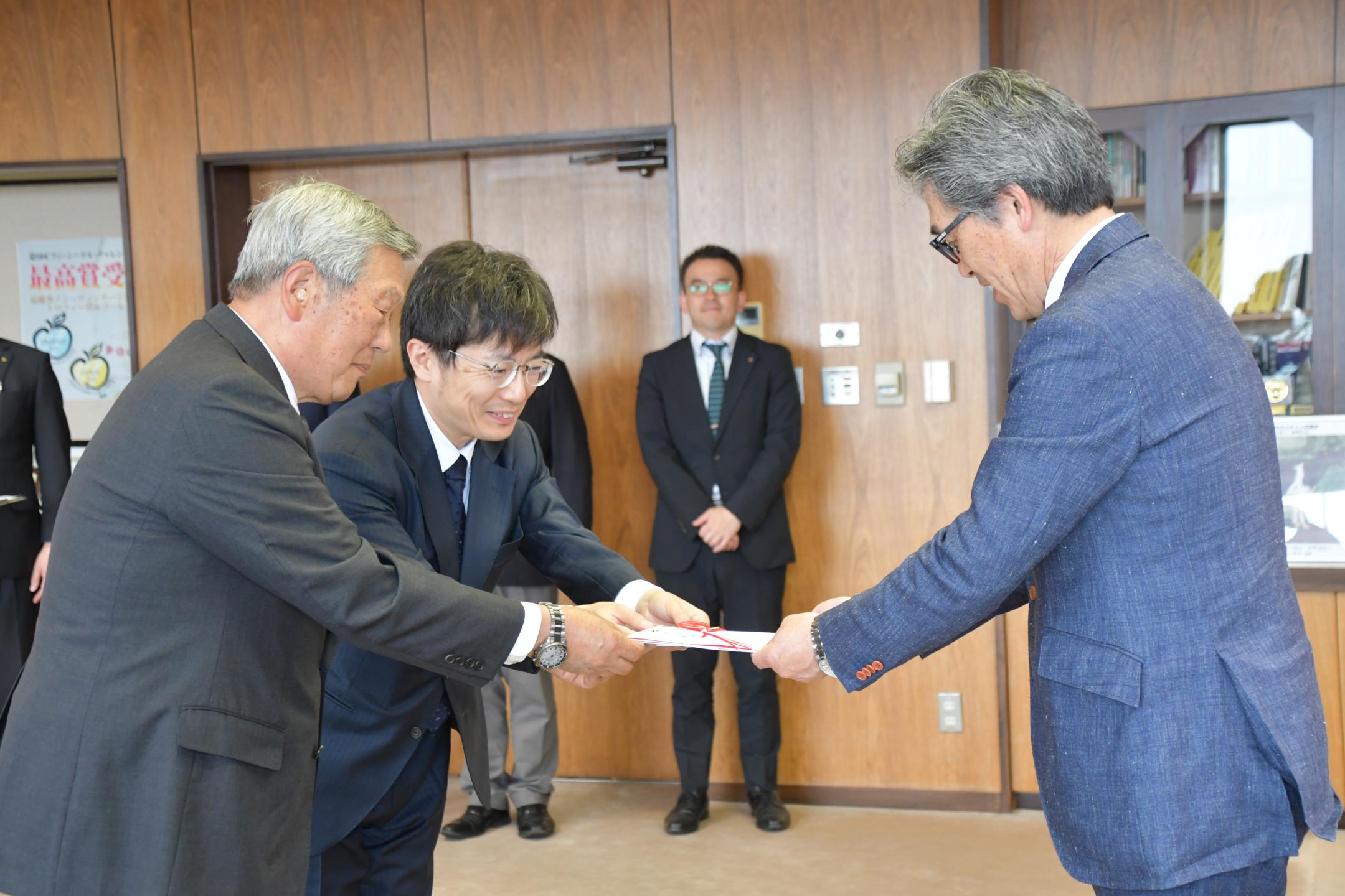 鷹木代表理事組合長と小笠原代表取締役から目録を受け取る市長