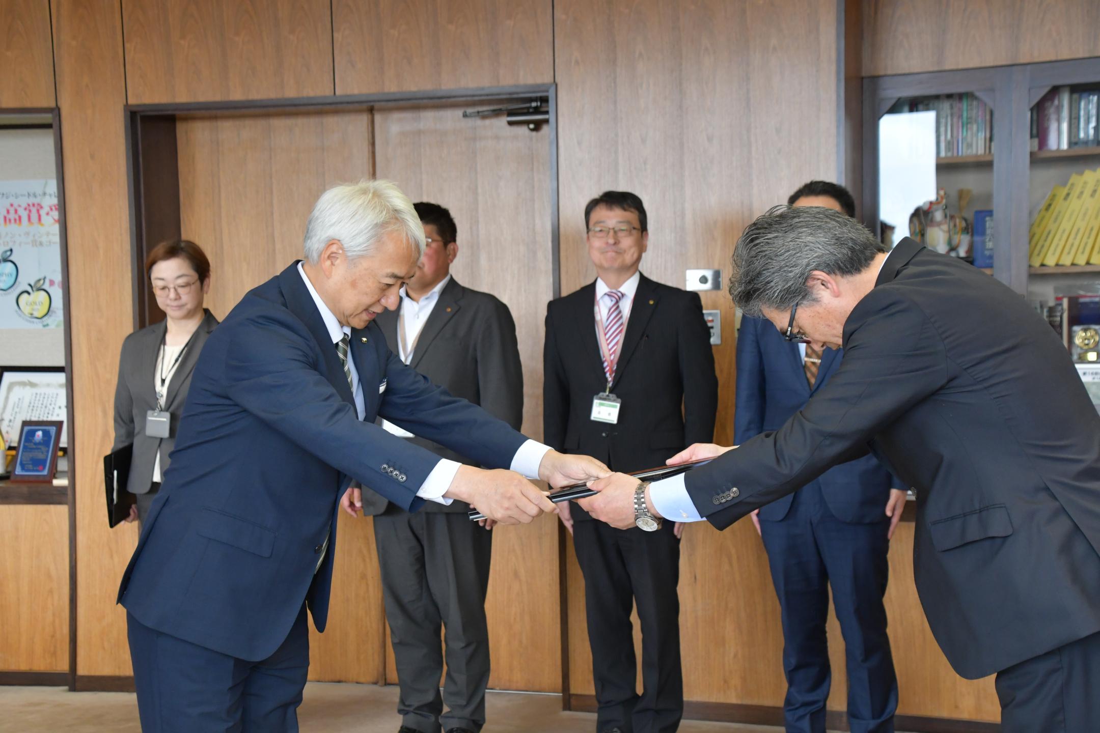 久保代表取締役社長執行役員から市長に目録が手渡されました