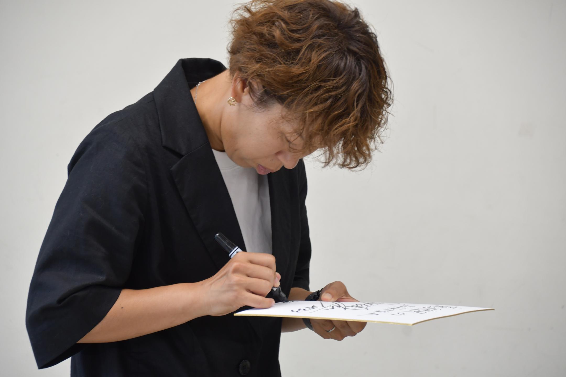 色紙にサインを書く岩清水さん