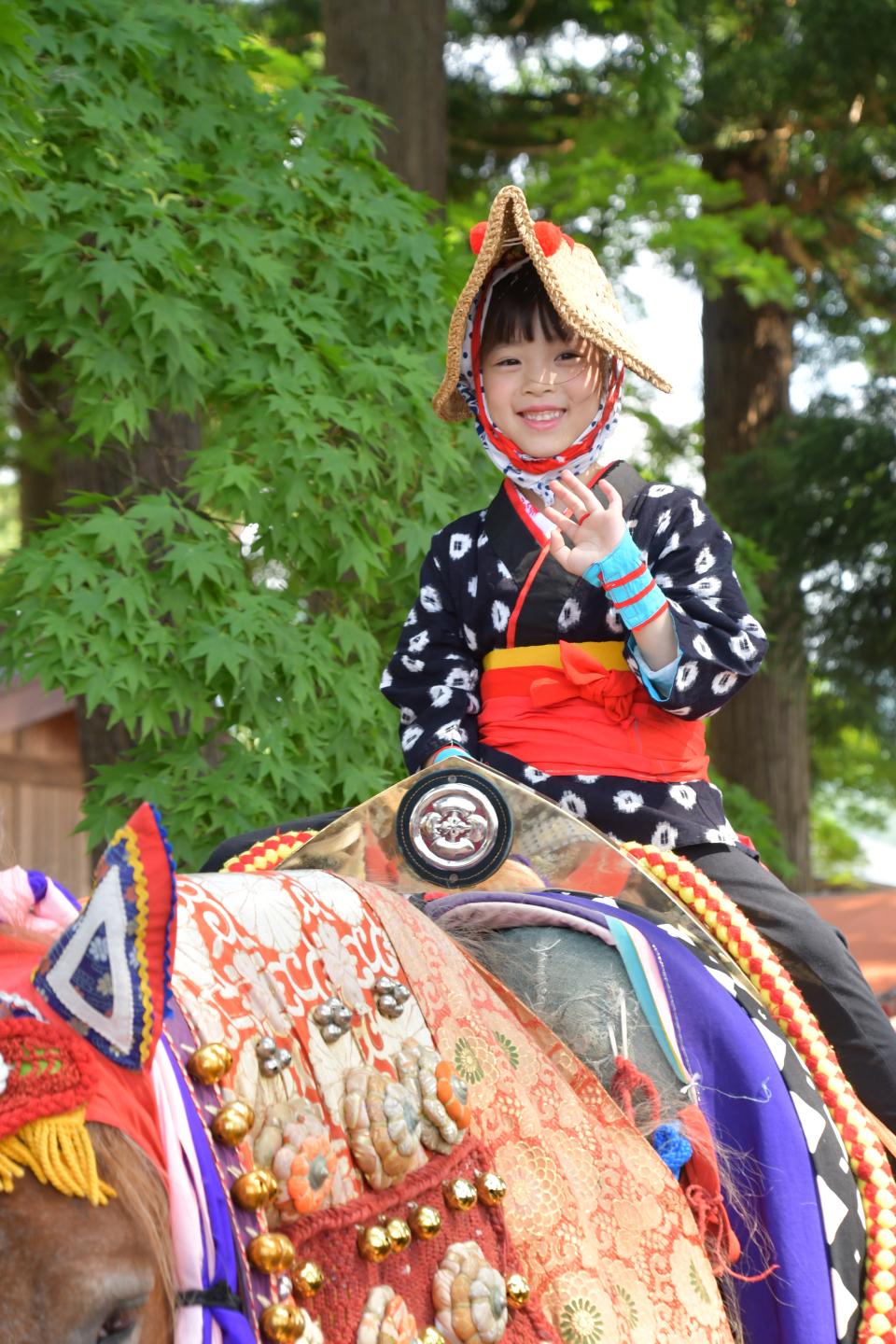 出発前に笑顔で手を振る乗り手の子ども