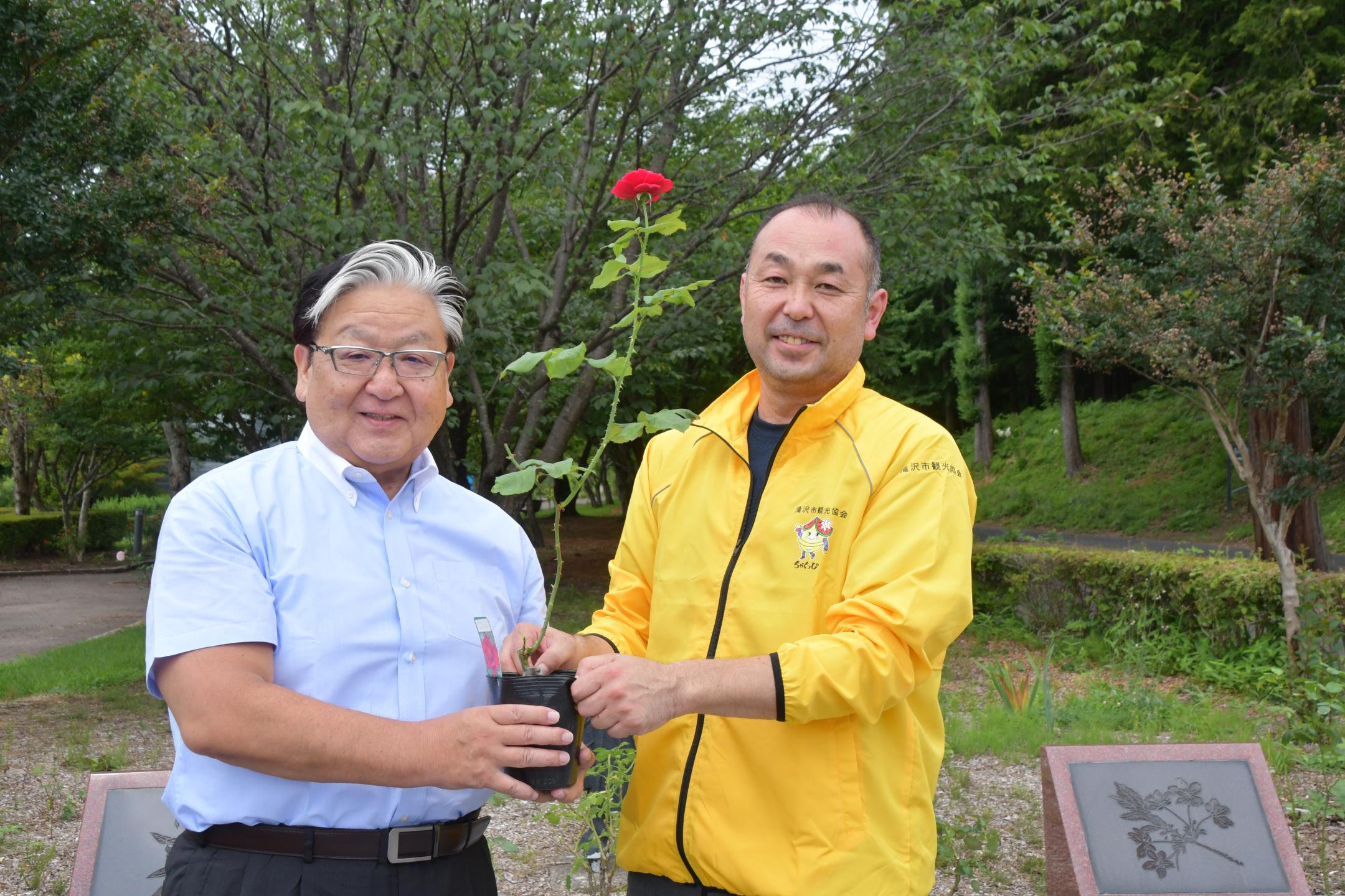 髙橋会長から苗を受け取る熊谷会長