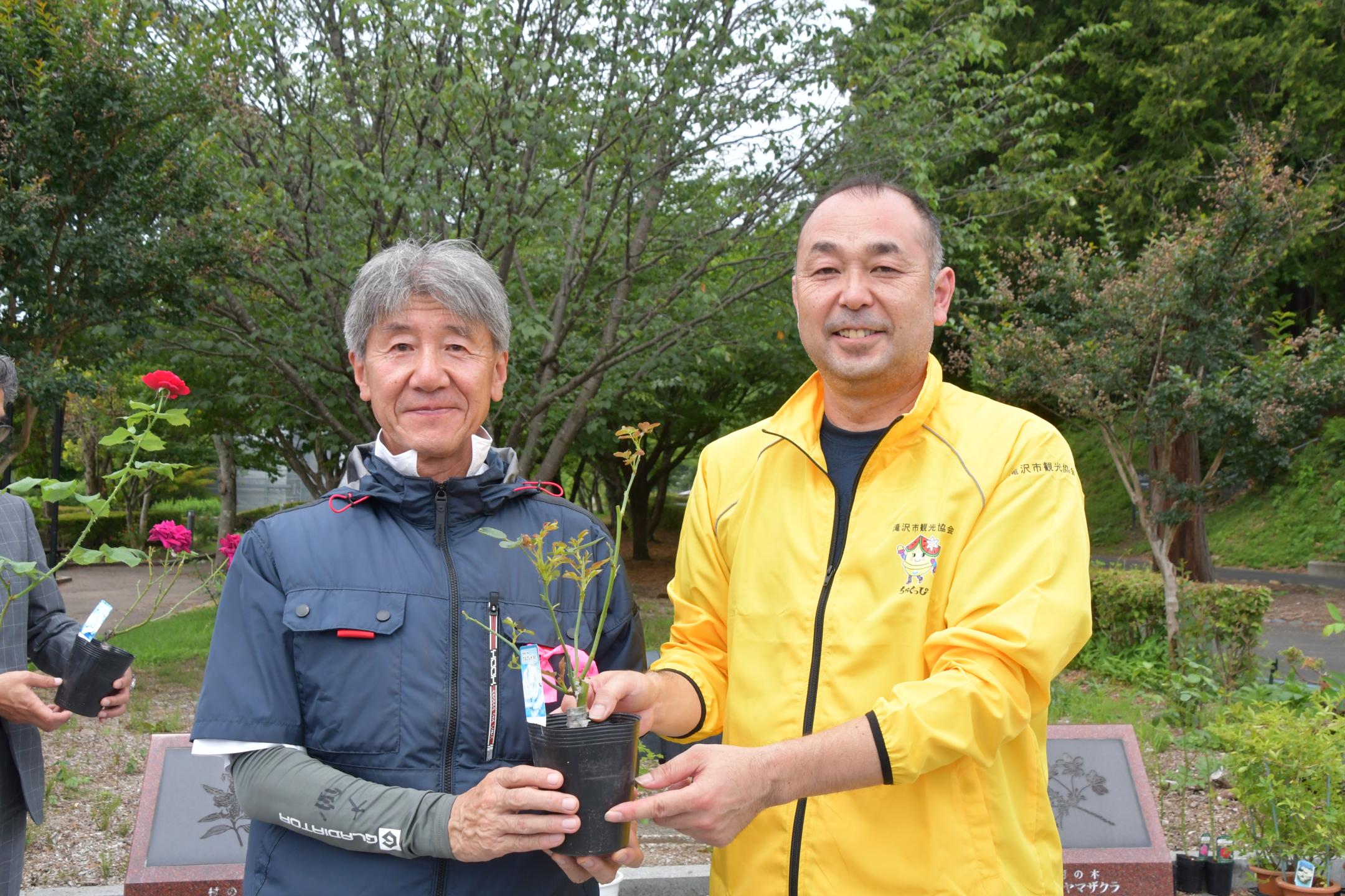 髙橋会長から苗を受け取る大宮副会長