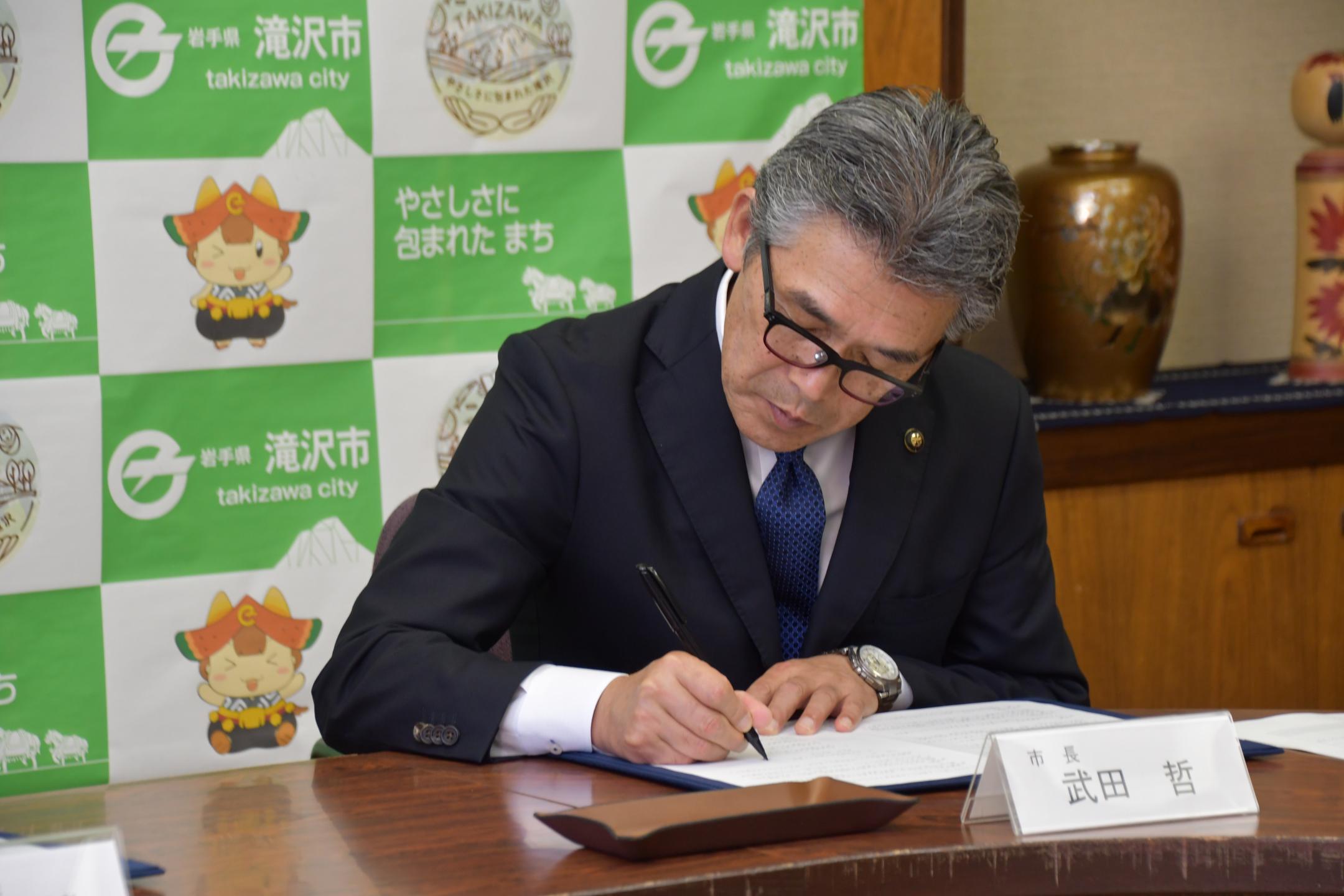 協定書に署名する市長