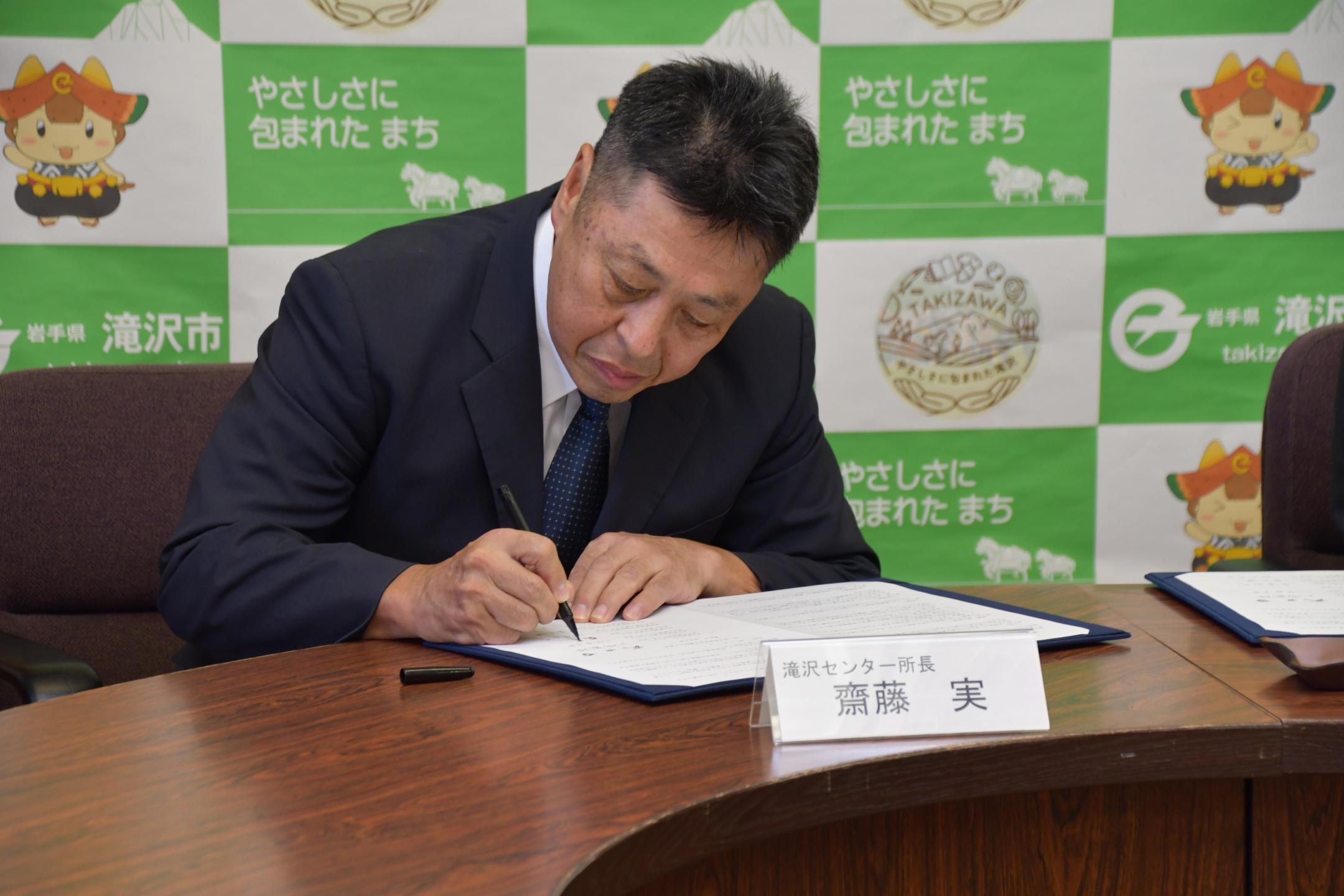 協定書に署名する齋藤所長
