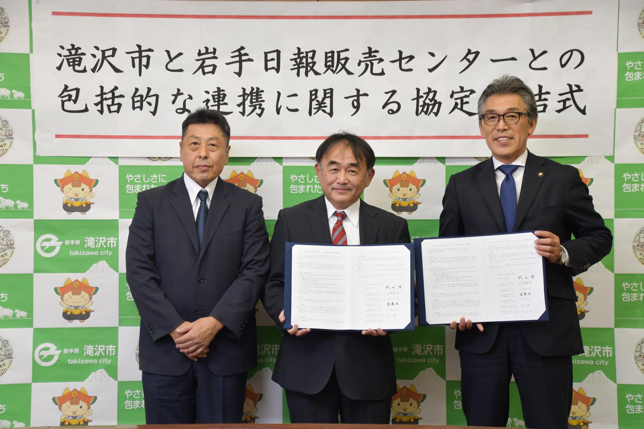 署名した協定書を開く左から齋藤所長、山崎所長、市長