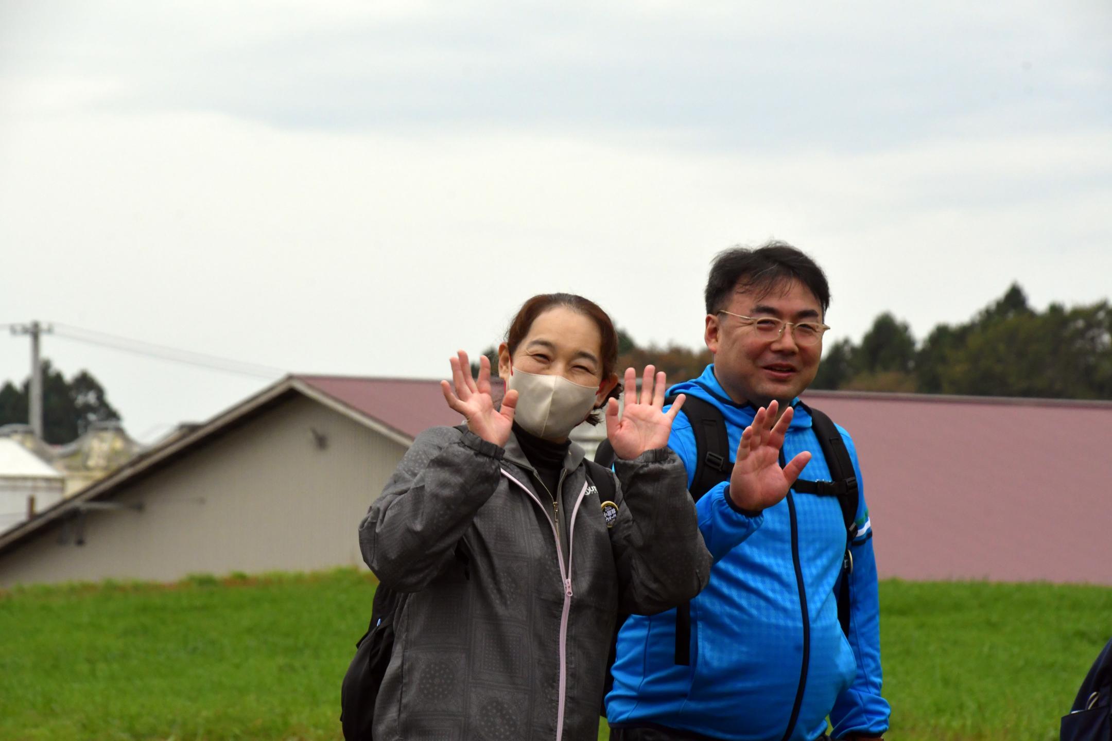 農場へ続く県道を笑顔で手を振り歩く参加者