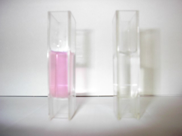（写真）水道水の入った2本の試験管。左側の試験管の水がピンク色になっている。