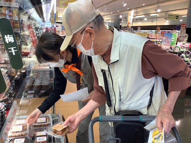 高齢者がスーパーで商品を眺めている様子